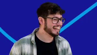 Man wearing a shirt and black T-shirt with glasses on a blue background.